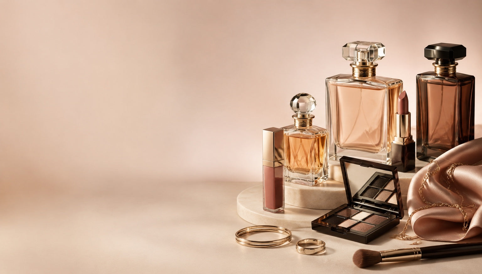 Perfume, cologne, and cosmetics arranged on a blush background